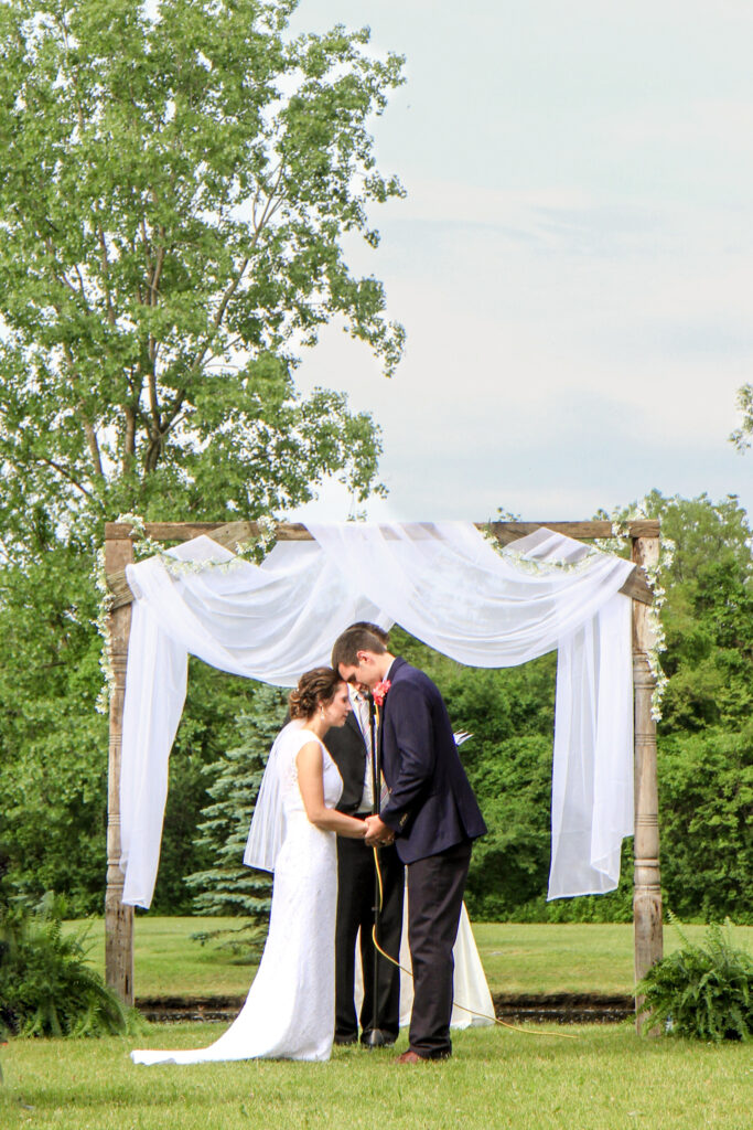 young couple on wedding day praying together at alter