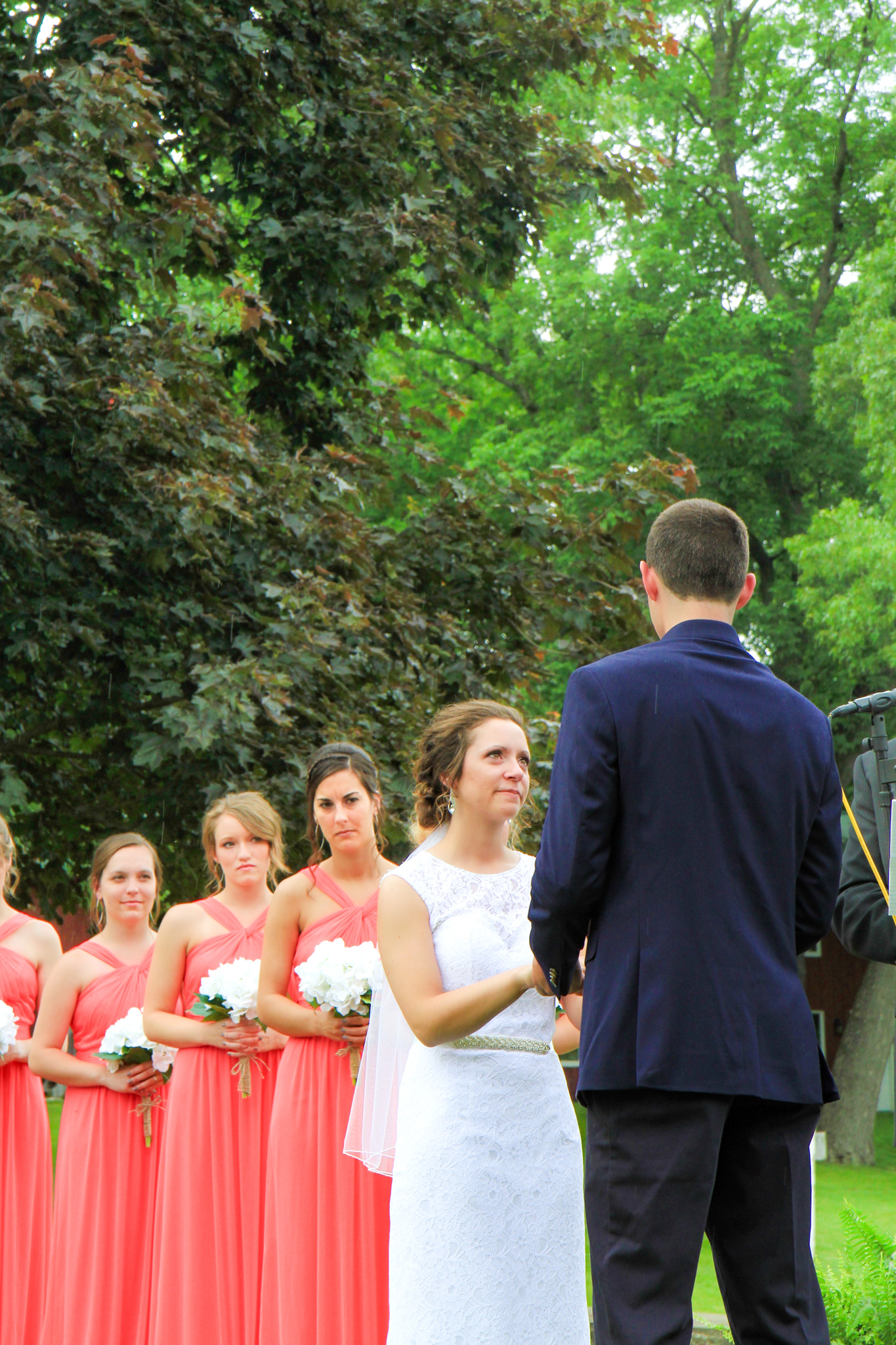 Young couple on wedding day, bride and bridesmaids looking at groom at the alter