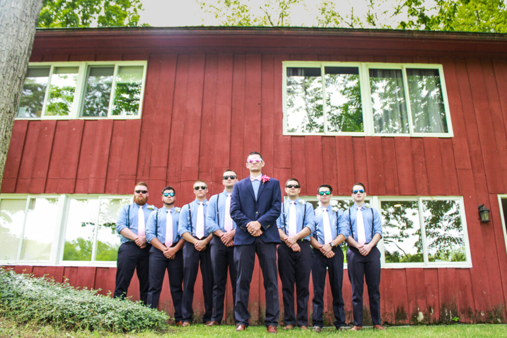 groom and groomsmen posing with sunglasses on and straight faces