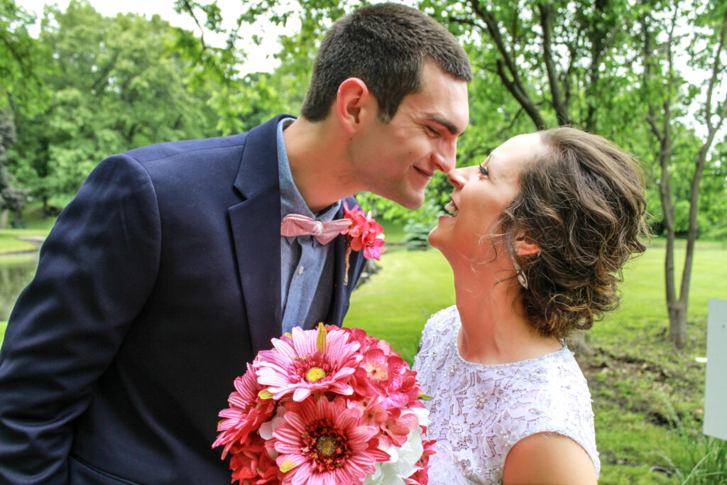 young couple on wedding day smiling at each other rubbing noses