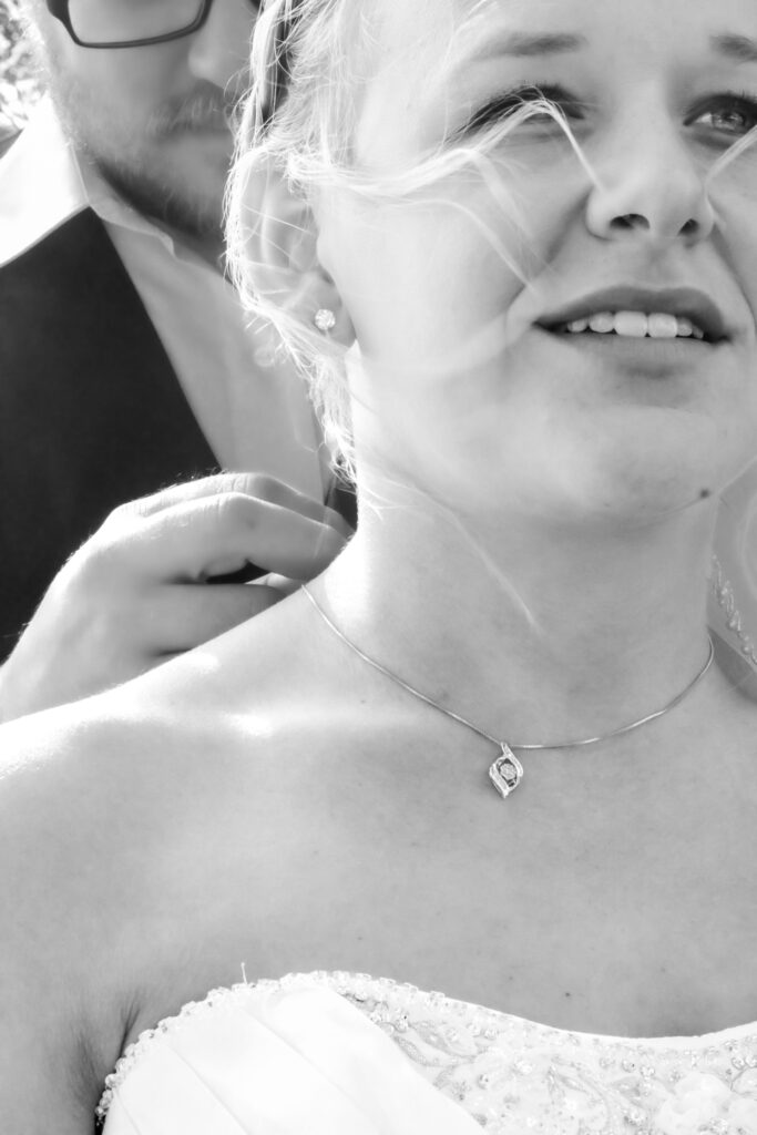 Groom puts on special necklace for bride