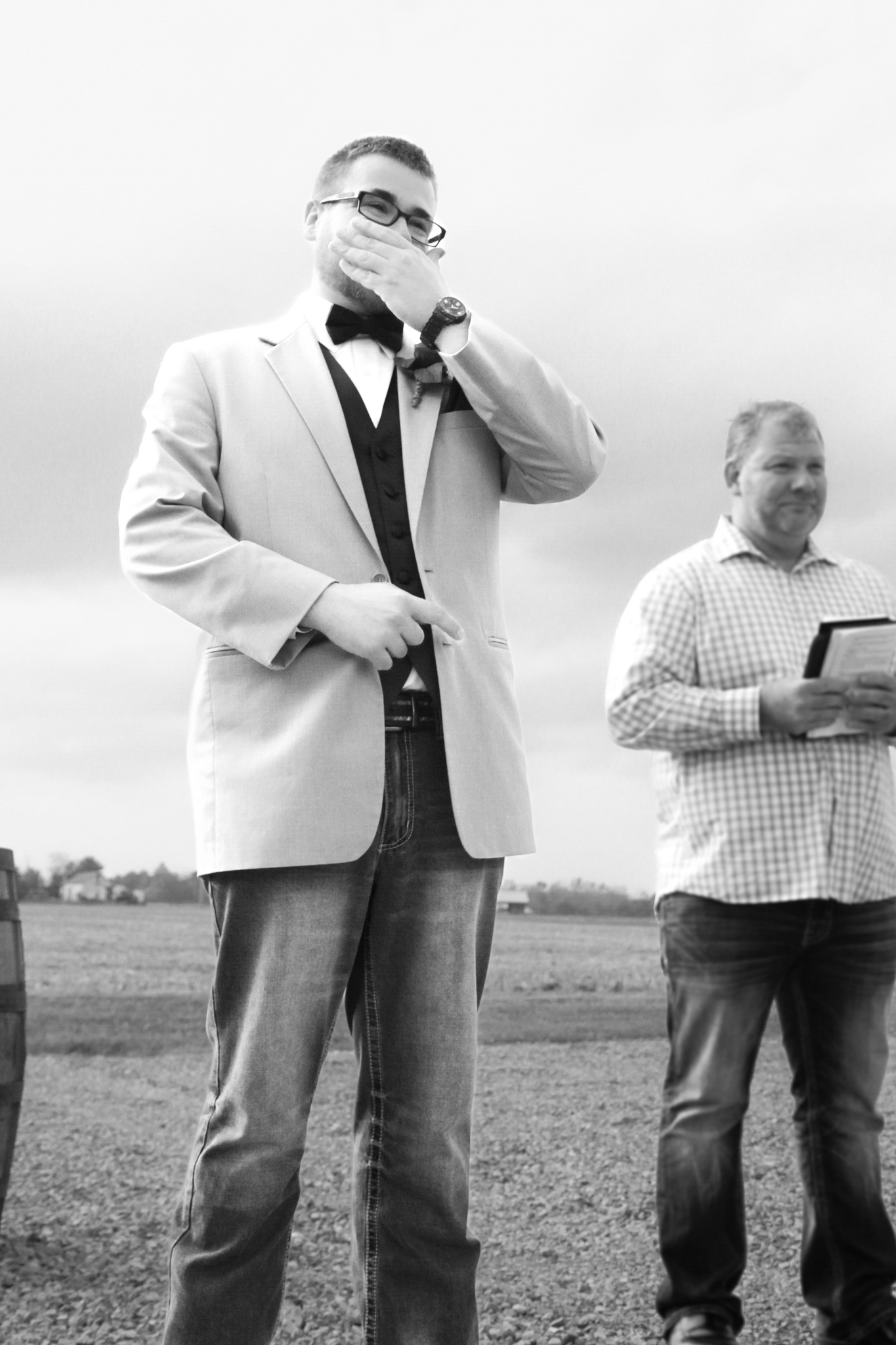 Groom covers mouth with joy while bride walks down aisle