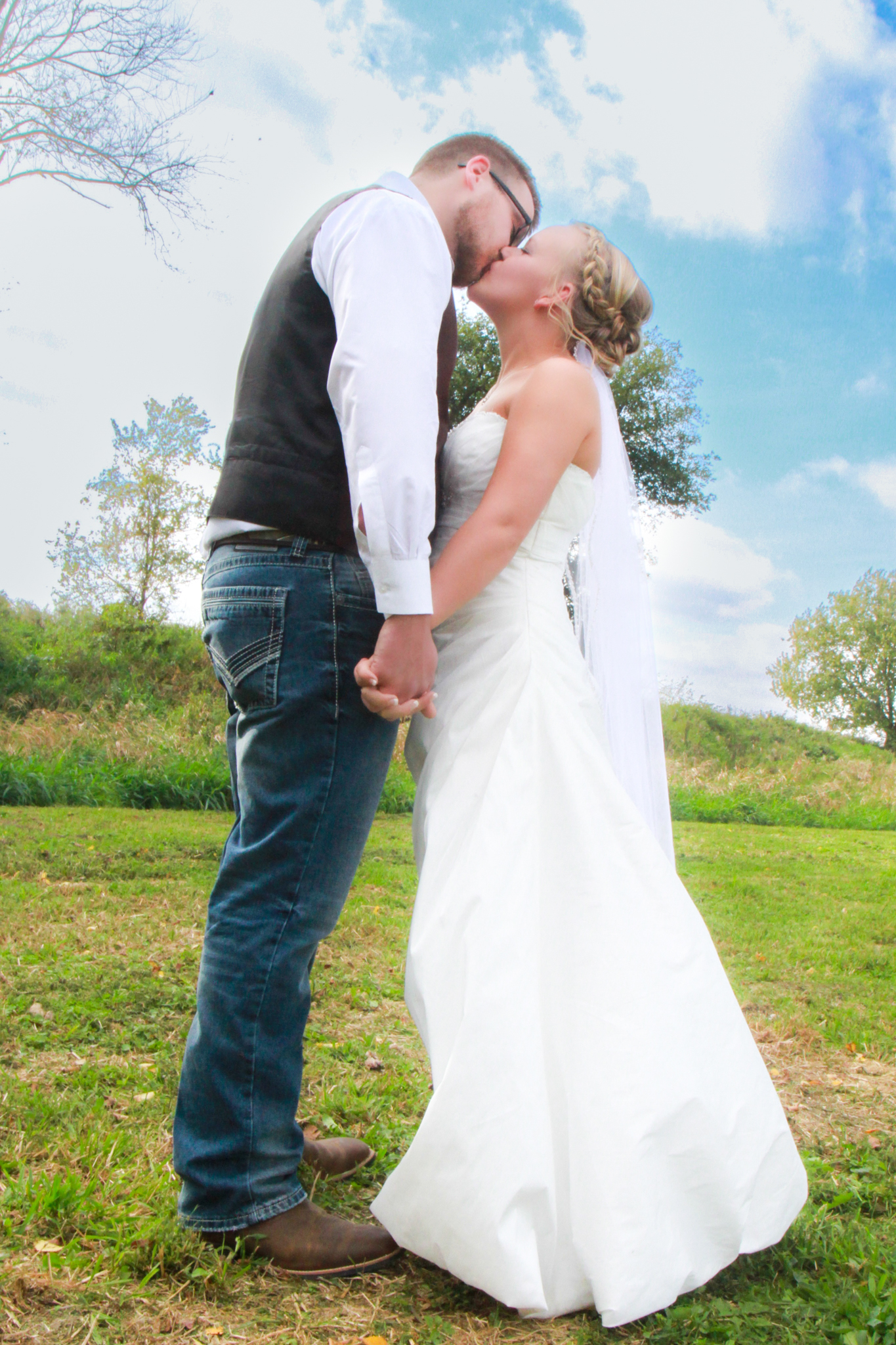 Groom and bride share kiss while holding hands