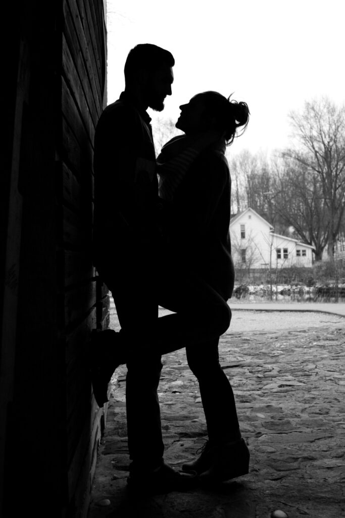 Young couple silhouetted, standing and looking at one another