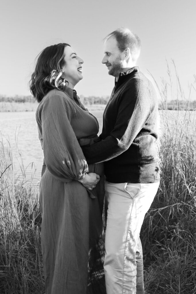 pregnant couple laugh together wife holds belly